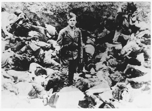 Ustasa man poses among the bodies of thos murdered in Jasenvoac